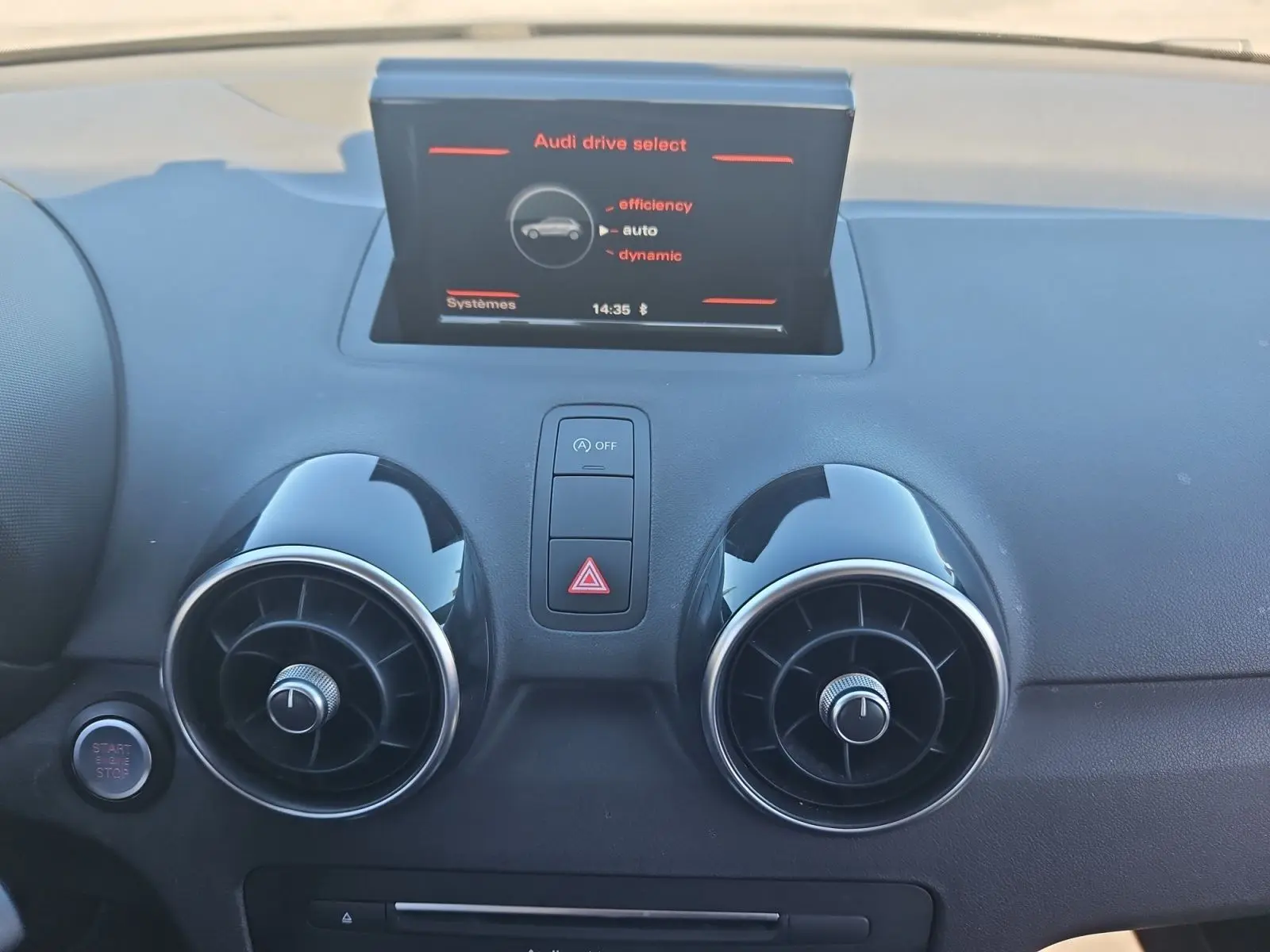Vue rapprochée du tableau de bord de l'Audi A1 Sportback 2016, avec écran central et aérateurs ronds noirs.