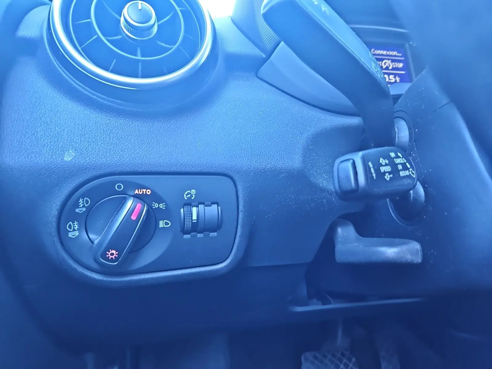 Détail du tableau de bord noir de l’Audi A1 Sportback 2016, avec commande d’éclairage et aérateur rond visible.
