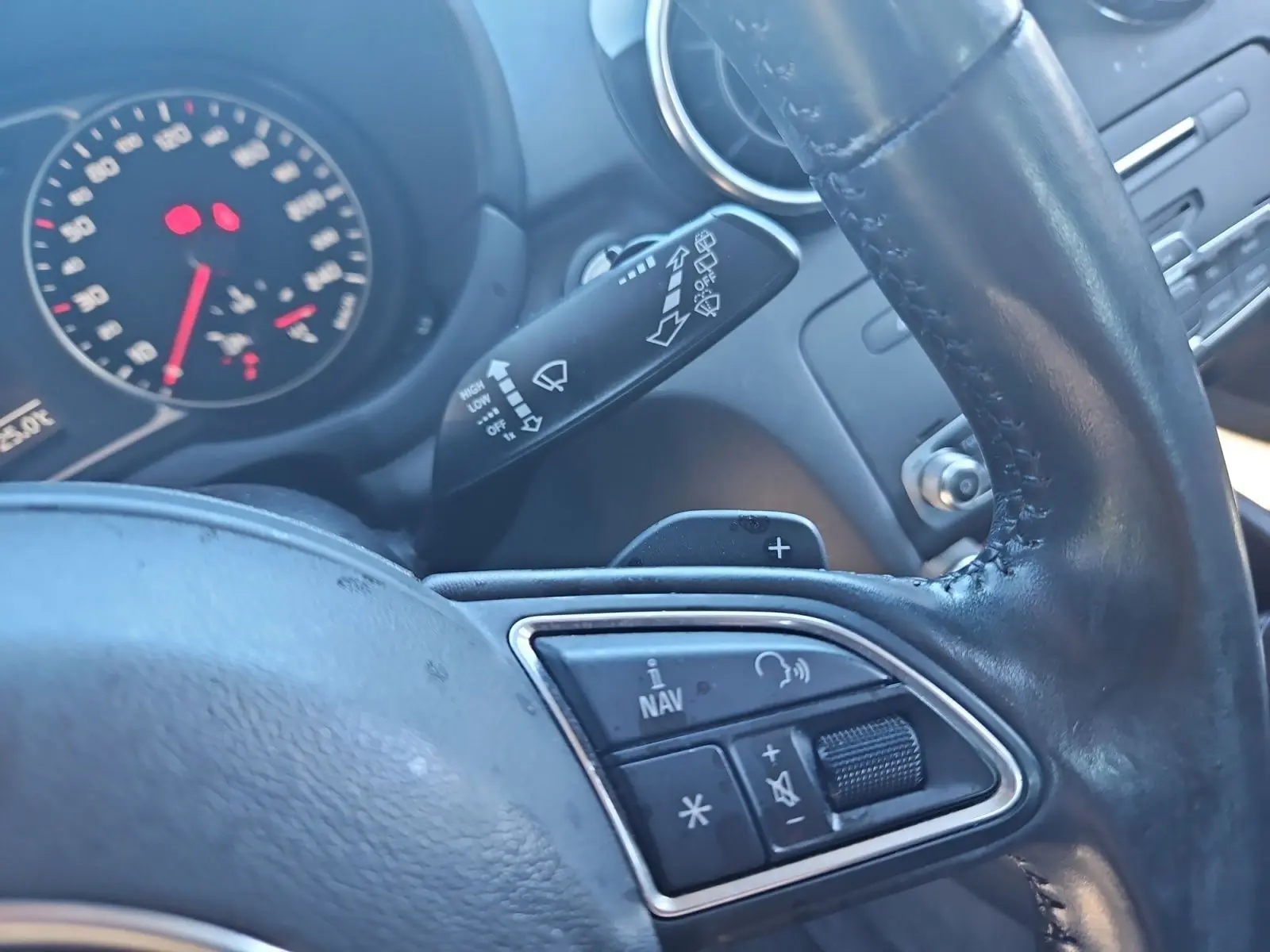 Gros plan sur le volant cuir noir d’Audi A1 Sportback 2016 avec commandes audio et palettes au volant visibles.