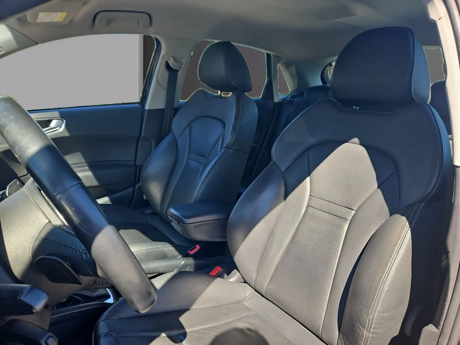 Vue intérieure montrant les sièges baquets en cuir noir et l'accoudoir central de l'Audi A1 Sportback 2016.