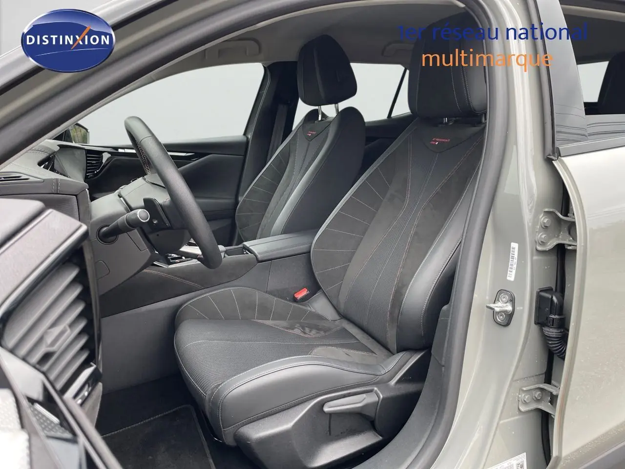 Intérieur côté conducteur du DS4 2024 gris laqué métal, sièges en cuir noir avec surpiqûres rouges visibles.