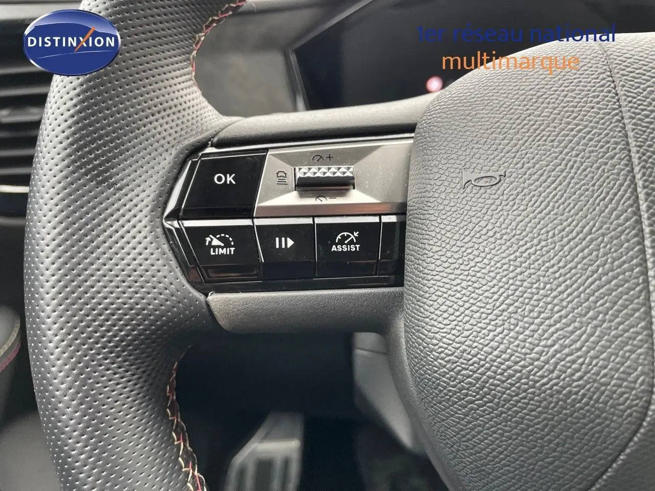 Gros plan sur le volant en cuir noir perforé du DS4 2024 avec commandes intégrées côté gauche.