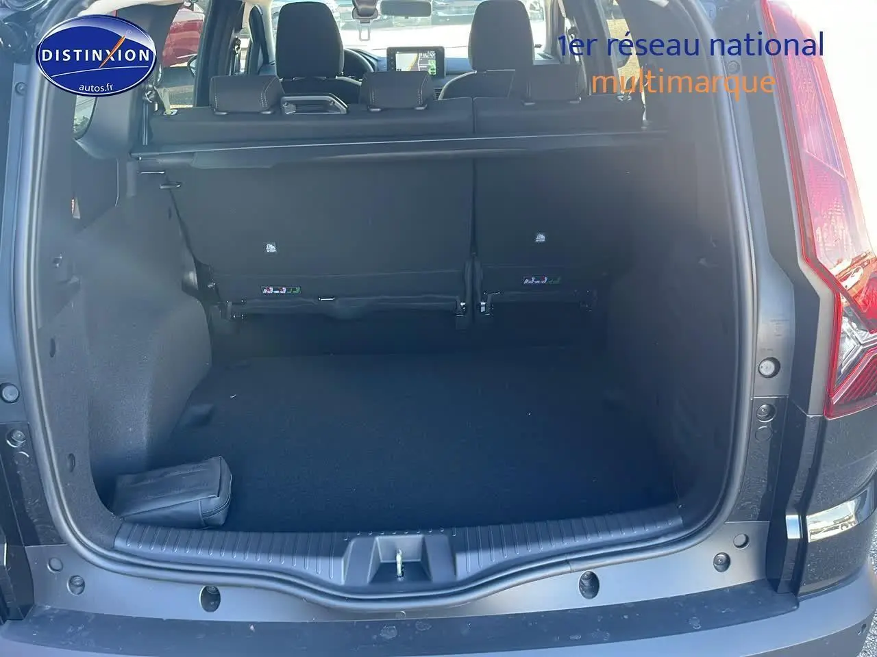 Coffre ouvert d'un Dacia Jogger noir nacré, vue arrière montrant la banquette arrière et l'espace de chargement vide.