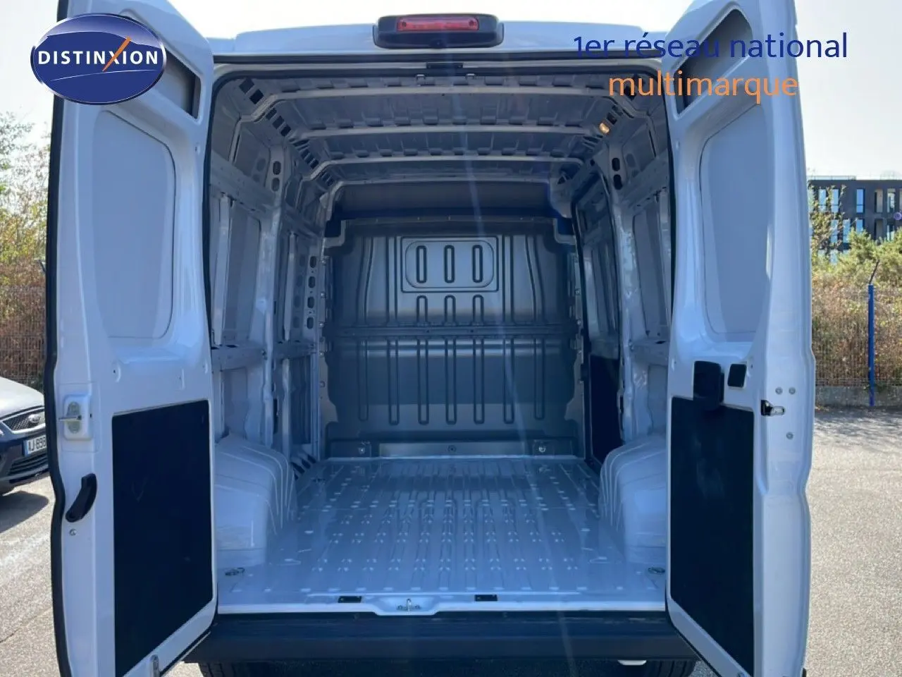 Vue arrière du Peugeot Boxer Fourgon blanc banquise 2025 avec portes arrière ouvertes montrant l'espace de chargement vide.