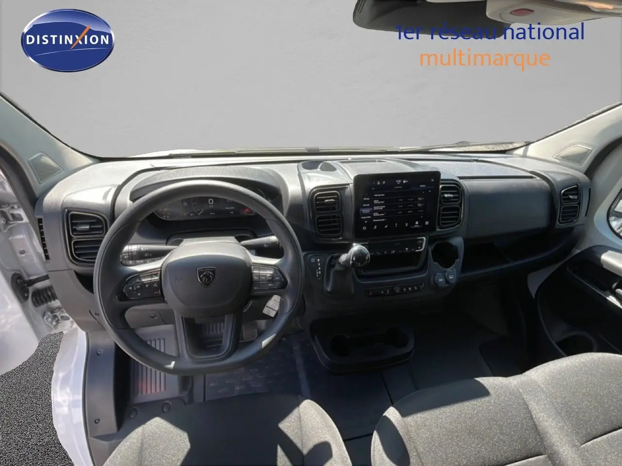 Vue intérieure avant du Peugeot Boxer Fourgon blanc banquise, tableau de bord avec écran tactile et volant multifonction.