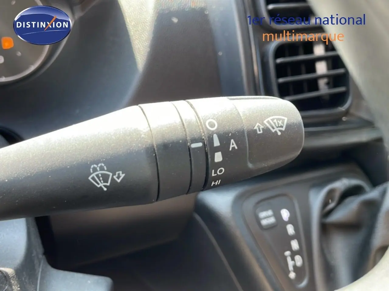 Gros plan sur la commande d’essuie-glace à gauche du volant dans l’habitacle du Peugeot Boxer Fourgon blanc banquise.
