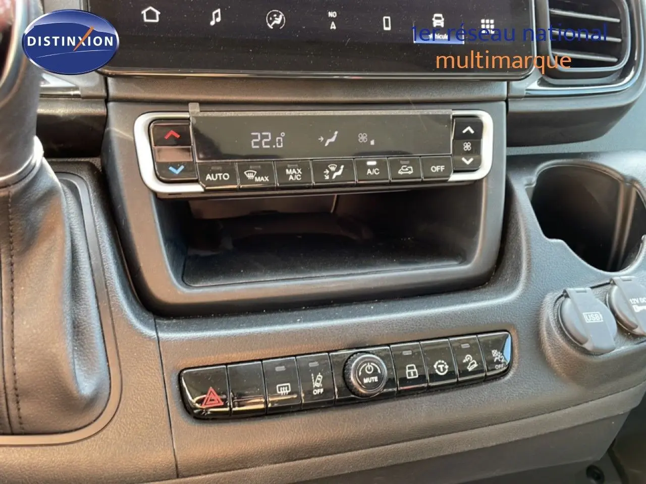 Vue rapprochée de la console centrale du Peugeot Boxer Fourgon blanc, avec commandes climatisation et boutons multifonctions.