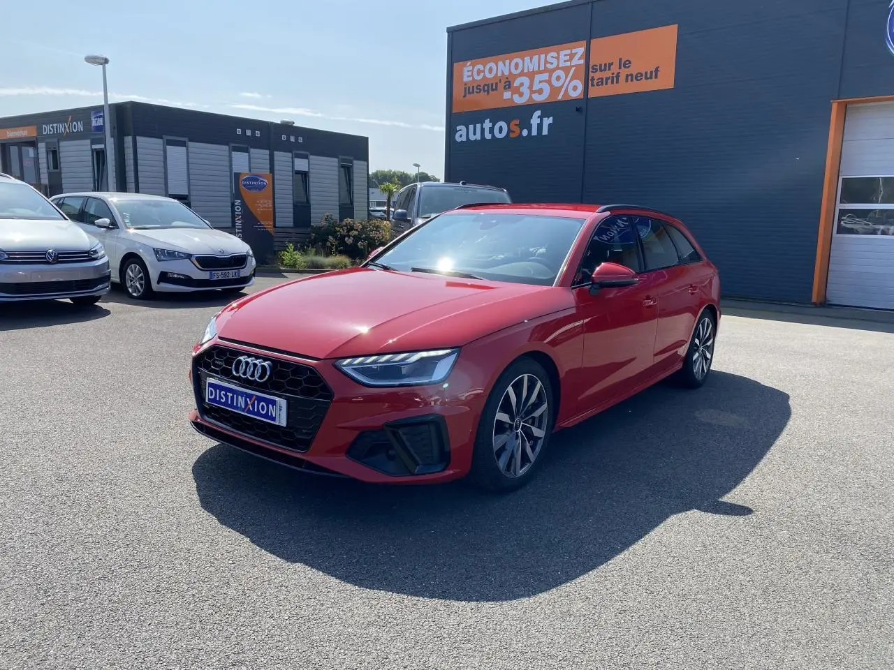 Audi A4 Avant S line rouge Tango vue 3/4 avant droit avec jantes 5 branches en Y sur parking extérieur.