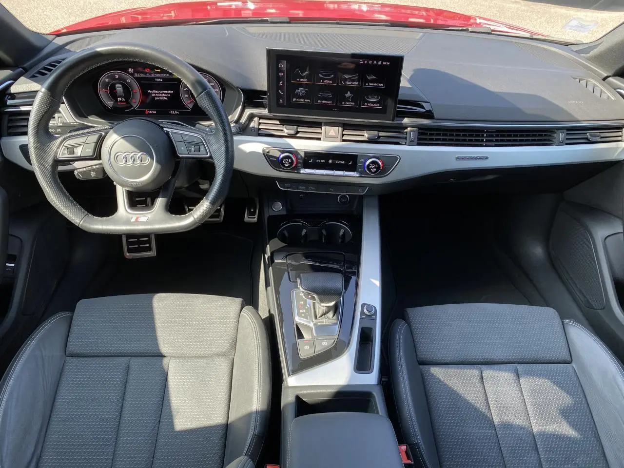 Vue intérieure frontale de l'Audi A4 Avant S line 2022, tableau de bord moderne avec écran central et volant multifonction cuir.