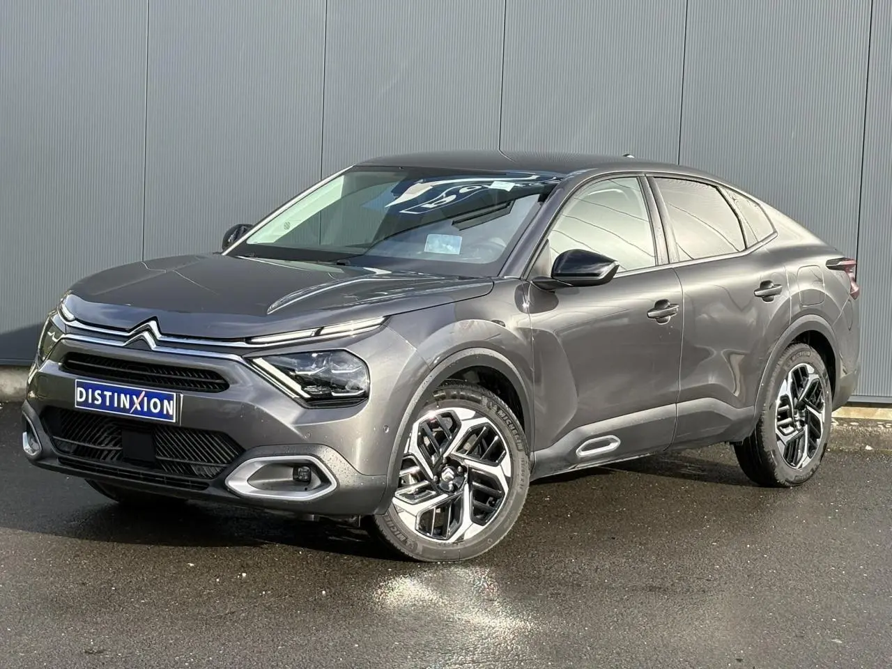 Vue 3/4 avant droit d'une Citroën C4 X 2024 gris Platinium avec jantes alliage et signature lumineuse LED en V.