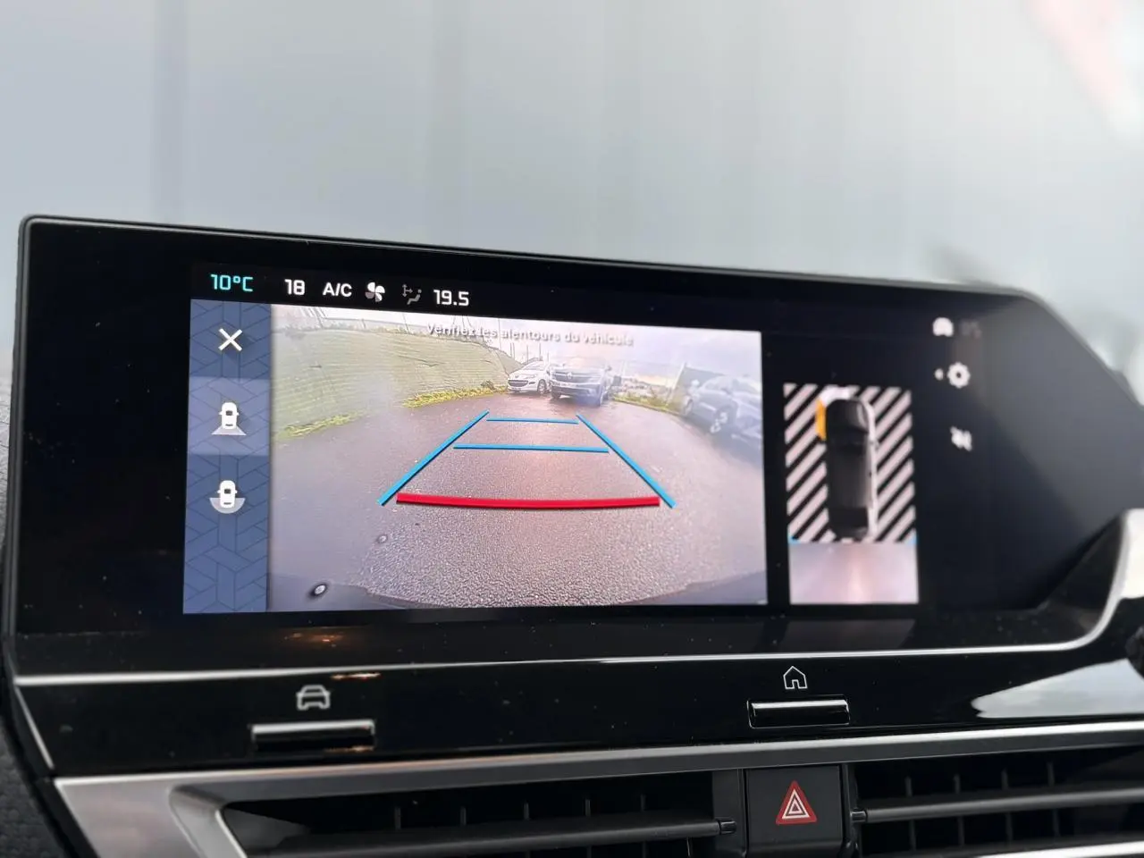 Écran tactile intérieur montrant la caméra de recul et l’aide au stationnement du Citroën C4 X gris Platinium.