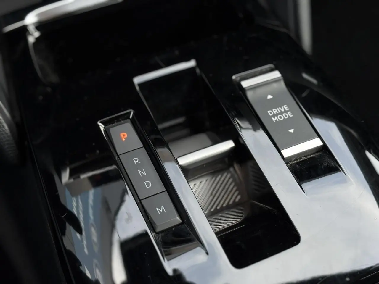 Gros plan sur la console centrale noire brillante avec commandes de boîte auto et mode de conduite de la Citroën C4 X.