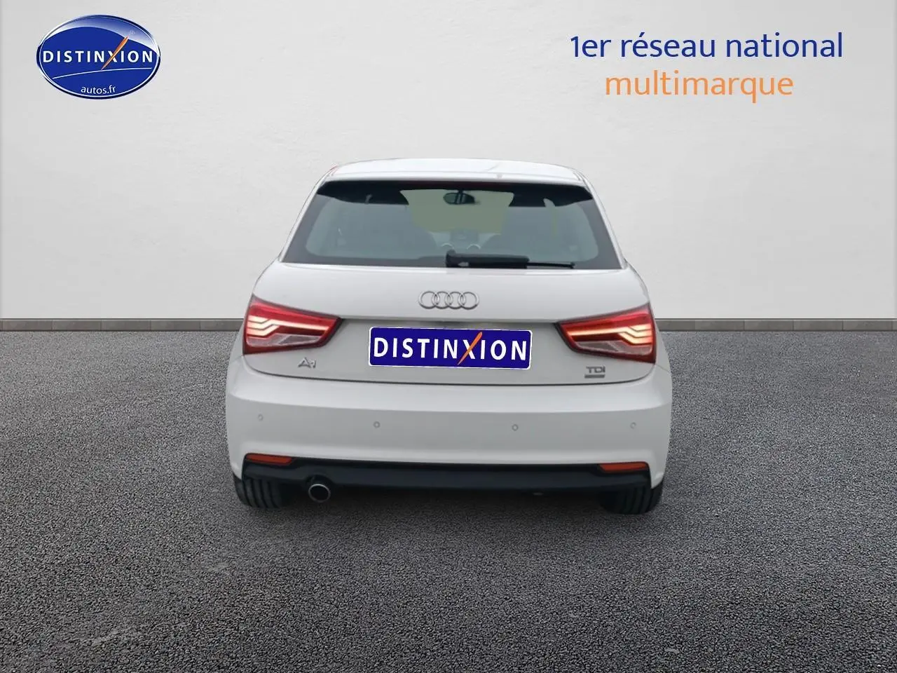 Vue arrière d'une Audi A1 blanche de 2015 avec feux LED et sortie d'échappement chromée visible côté gauche.