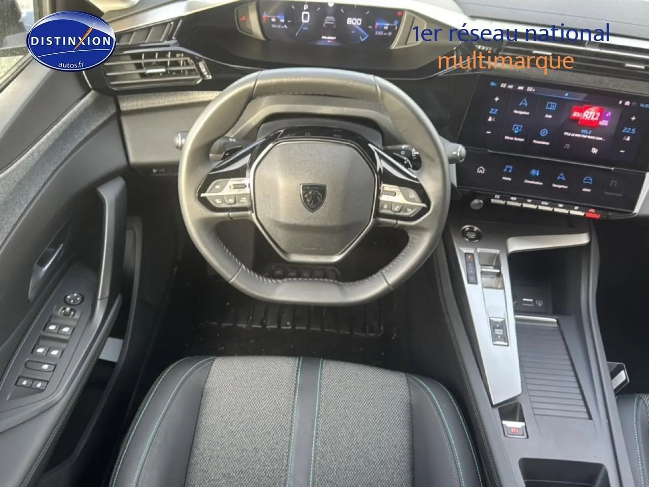 Vue intérieure centrée sur le volant multifonction et le tableau de bord numérique de la Peugeot 308 gris Sellenium.