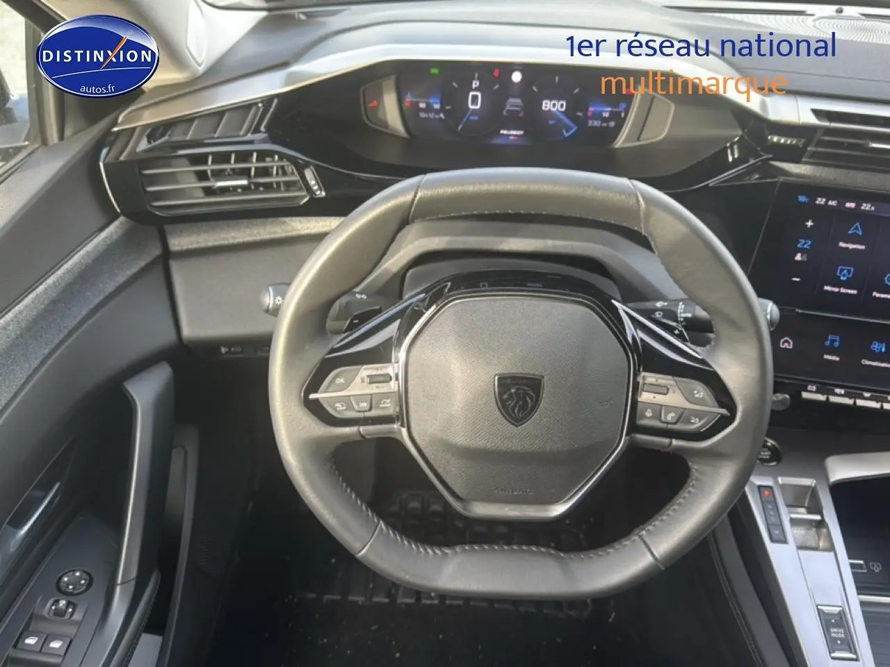 Vue intérieure centrée sur le volant multifonction noir de la Peugeot 308 2024 avec tableau de bord digital et écran tactile.