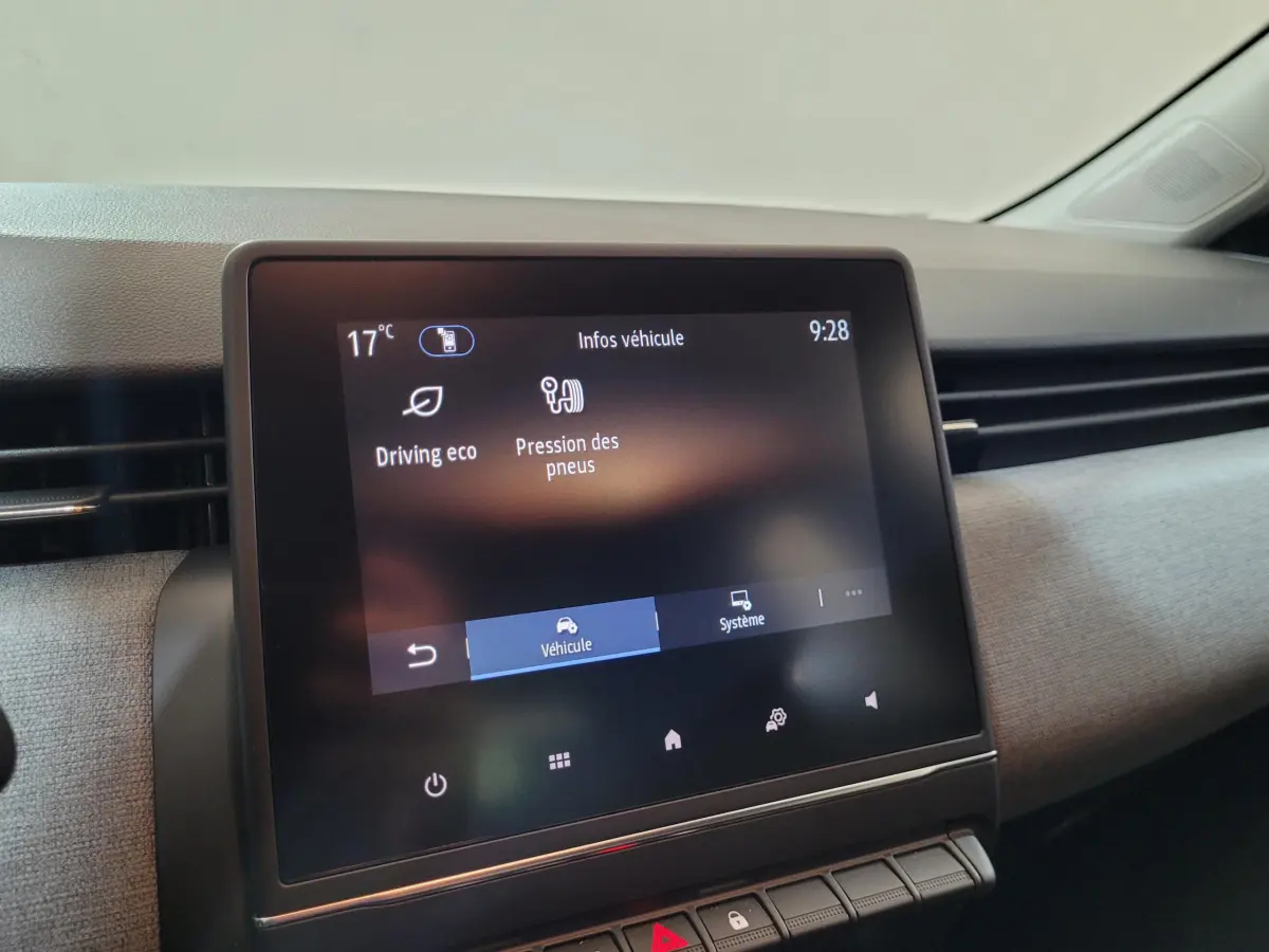 Vue rapprochée de l'écran tactile central du tableau de bord de la Renault Clio gris foncé, affichant les infos véhicule.