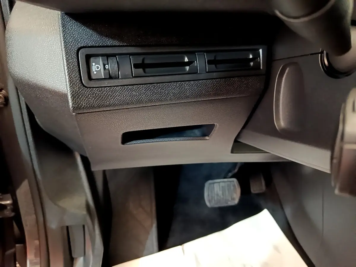 Détail de la console inférieure côté conducteur du Peugeot 5008 2021 avec commandes d’éclairage et pédalier visible.