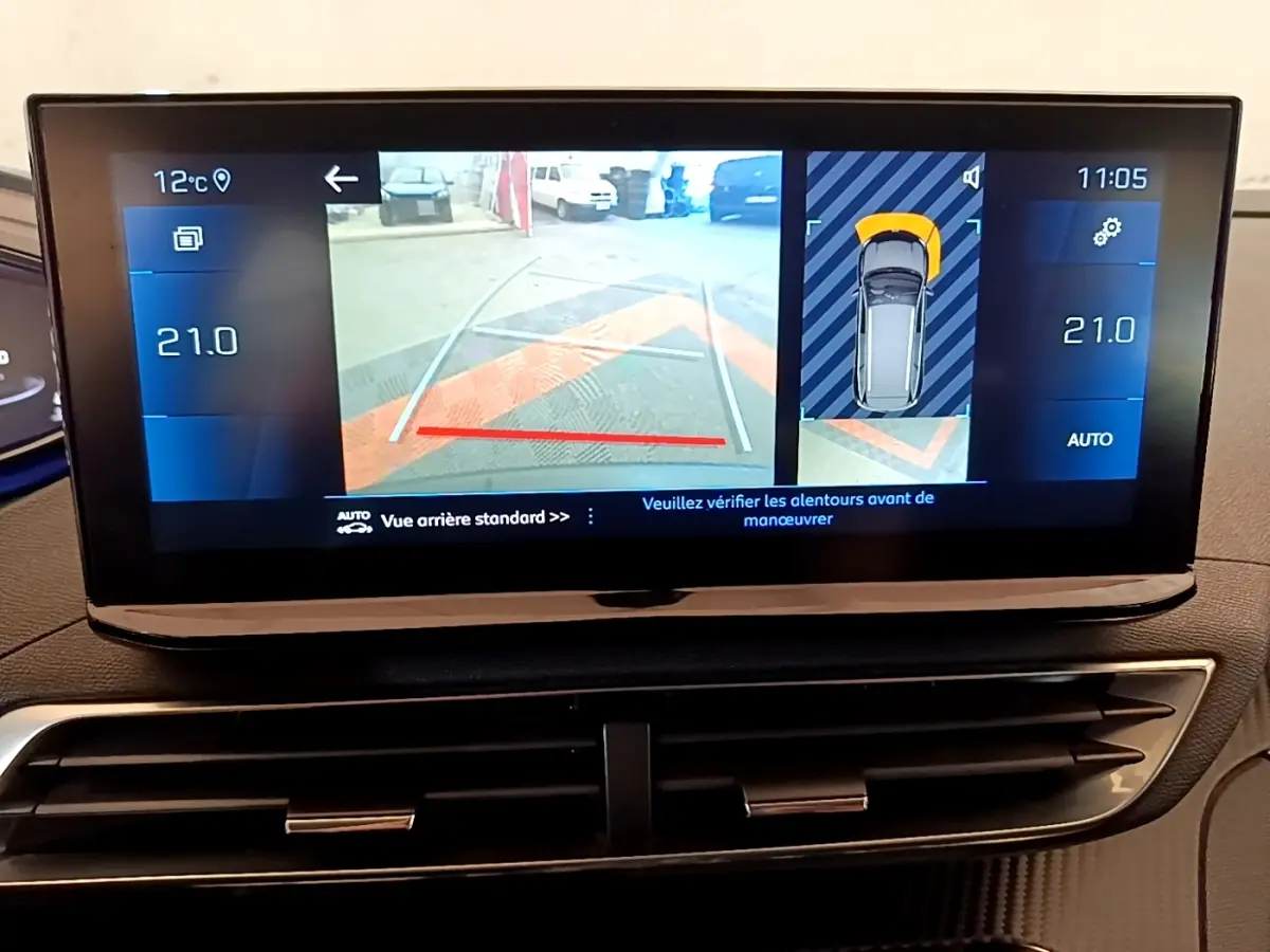 Écran tactile intérieur du Peugeot 5008 gris clair montrant la caméra de recul et l'aide au stationnement arrière.