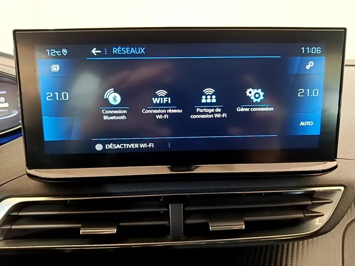 Écran tactile central affichant les options Wi-Fi et Bluetooth dans l'habitacle du Peugeot 5008 gris clair.