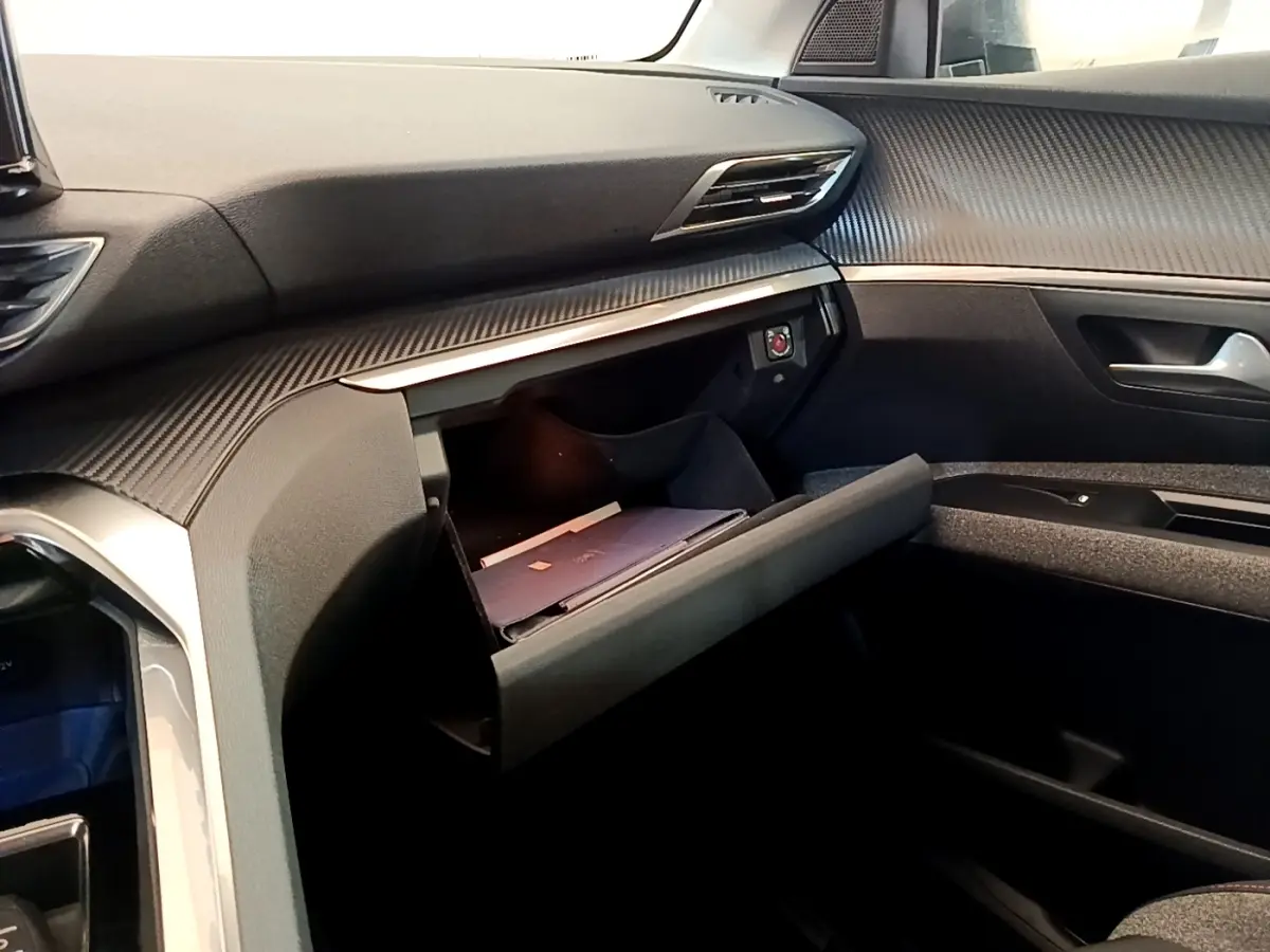 Vue intérieure côté passager du tableau de bord gris foncé avec boîte à gants ouverte du Peugeot 5008 2021.