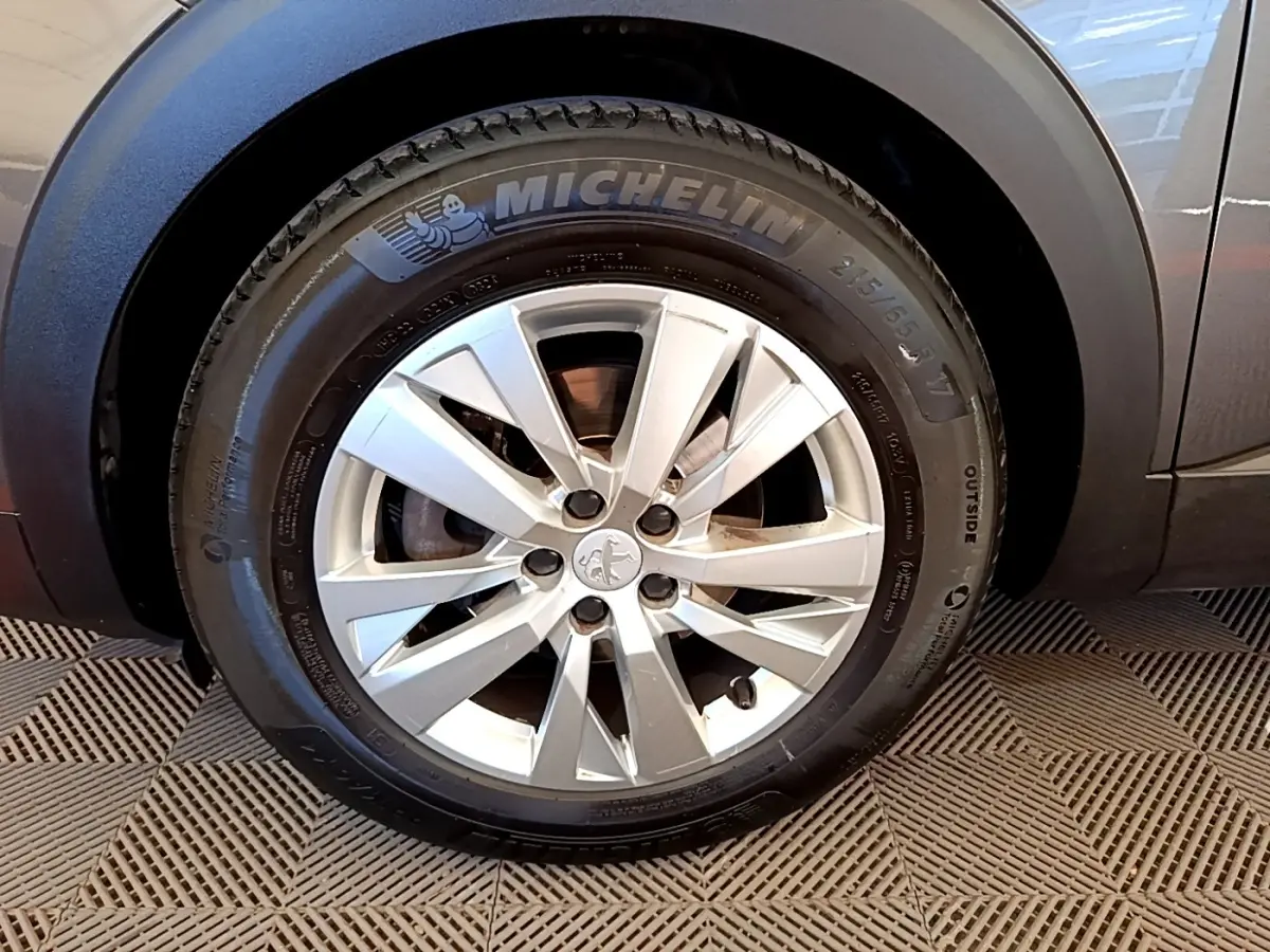 Gros plan sur la roue avant droite grise du Peugeot 5008 avec jante alliage et pneu Michelin visible.