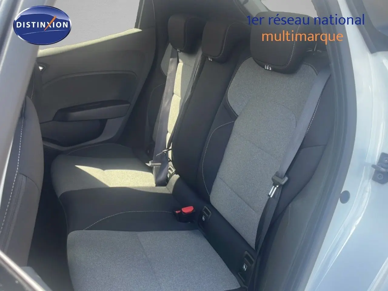 Vue intérieure côté droit montrant les sièges arrière en tissu gris et noir d'une Renault Clio blanche 2025.