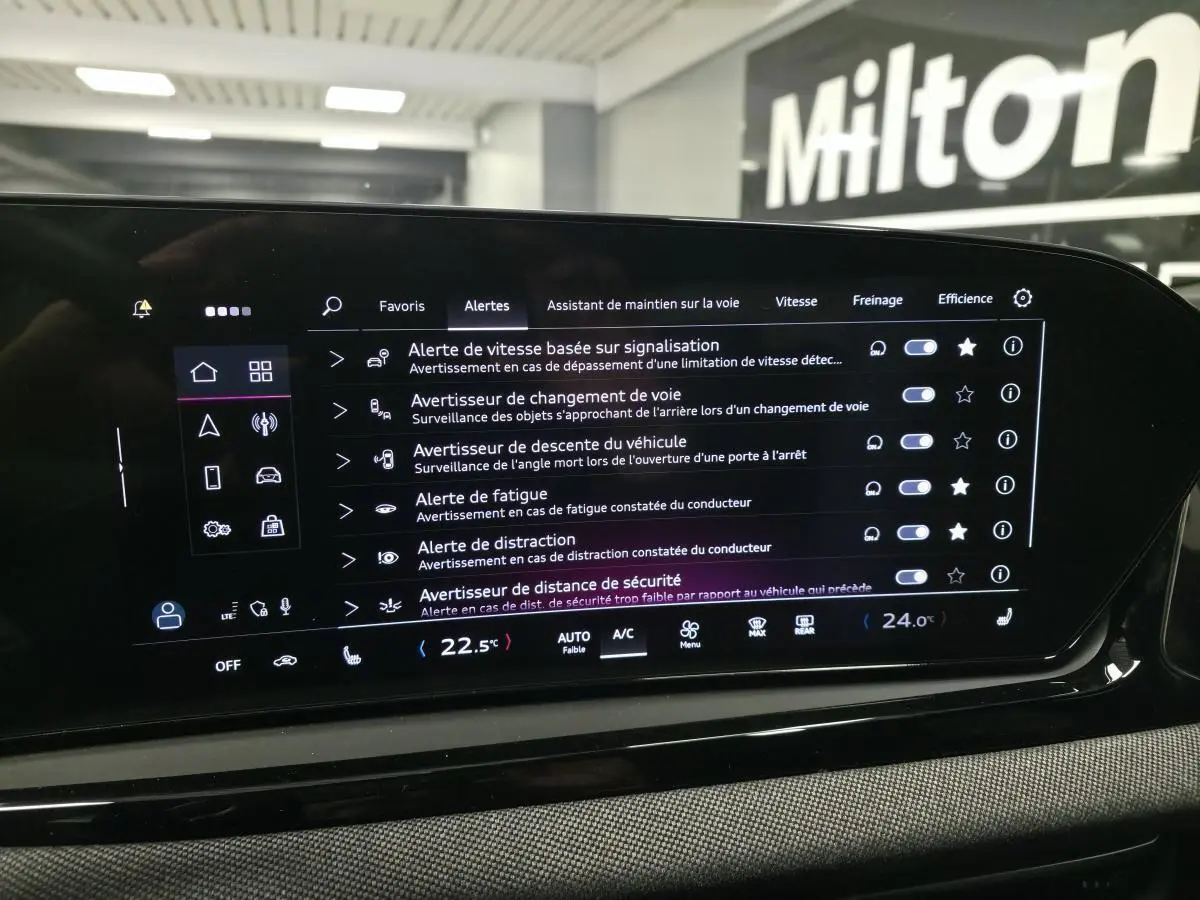 Écran tactile intérieur affichant les réglages d'assistance à la conduite de l'Audi A5 Avant noir, vue de face.