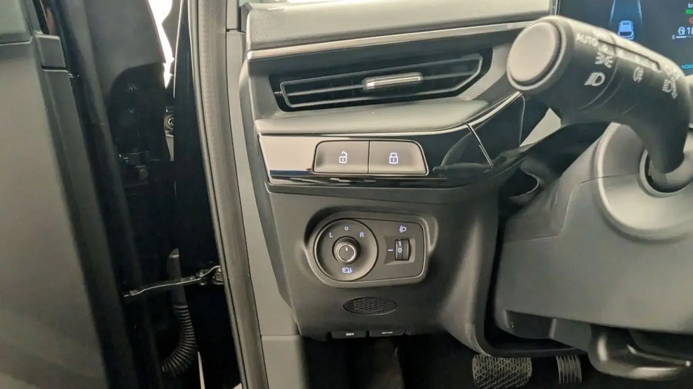 Détail du tableau de bord côté gauche du MG3 1.5 HYBRID+ 195 LUXURY noir, avec commandes des rétroviseurs et verrouillage centralisé.