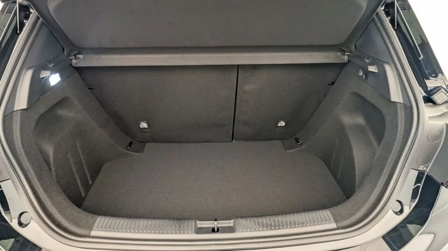 Coffre ouvert vu de l'arrière d'une MG3 1.5 HYBRID+ 195 LUXURY en Pebble Black, intérieur noir spacieux et propre.
