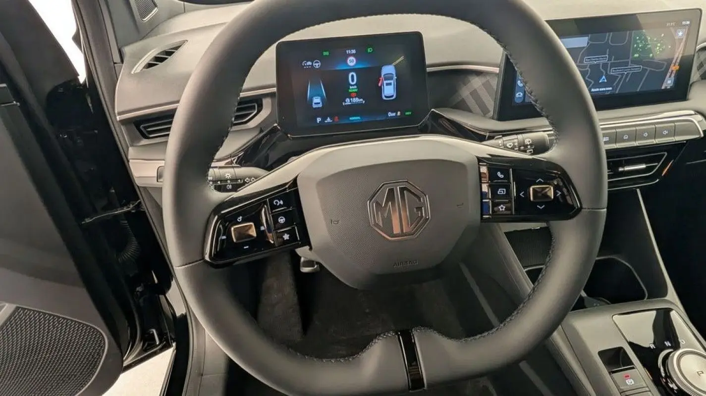 Vue intérieure centrée sur le volant noir du MG3 1.5 Hybrid+ 195 Luxury avec tableau de bord digital et écran tactile.