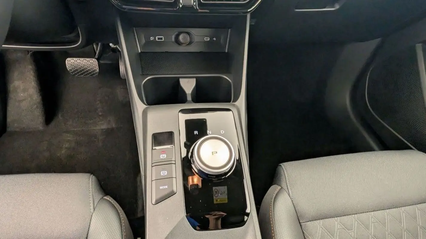 Vue plongeante sur la console centrale du MG3 1.5 HYBRID+ 195 LUXURY 2026 avec molette de boîte auto et sièges gris.