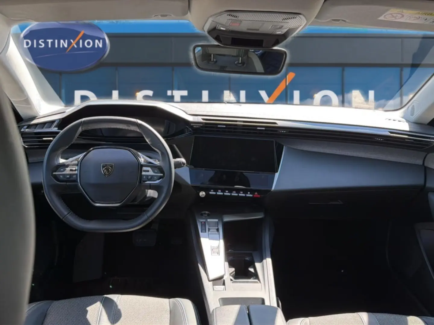 Intérieur avant de la Peugeot 408 Hybrid 145 bleu, vue centrée sur le volant et l'écran tactile du tableau de bord.