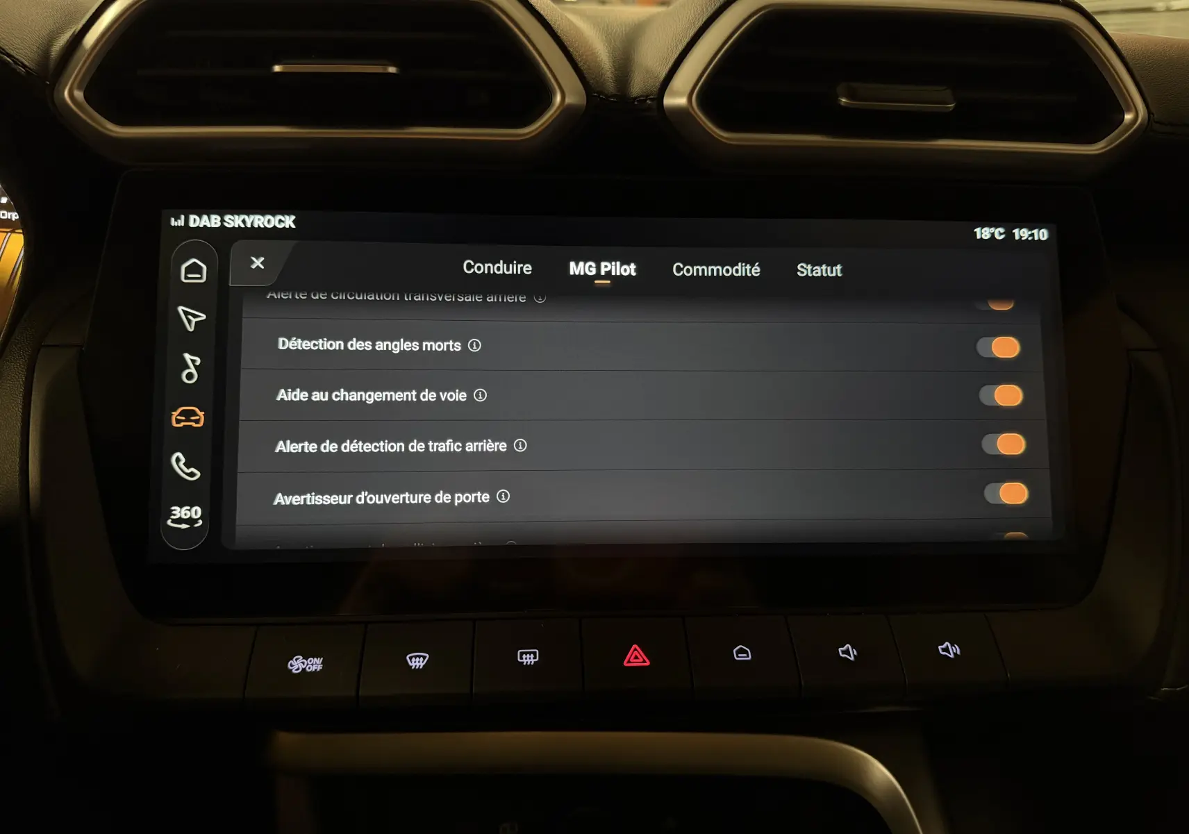 Écran tactile central du MG ZS 2026 affichant les options d'aide à la conduite, entouré de commandes et aérateurs noirs.