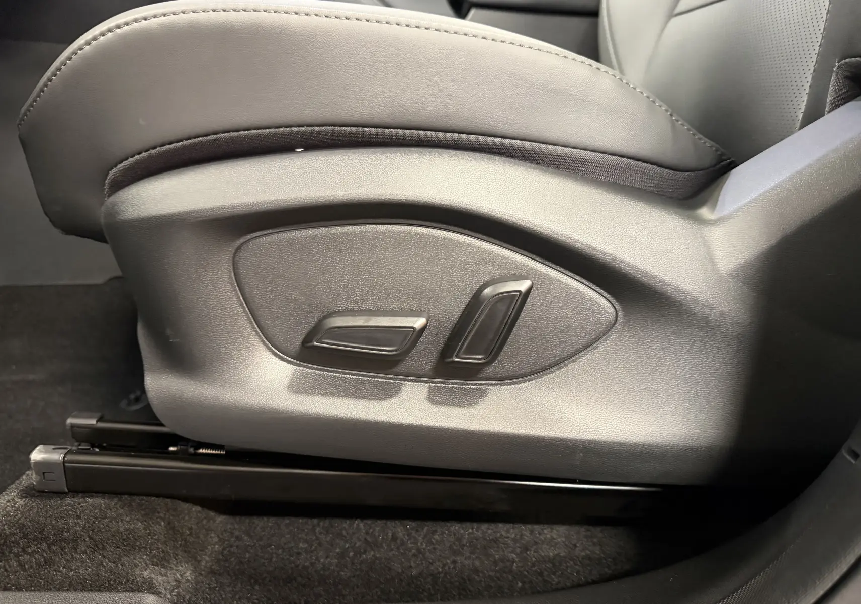 Gros plan sur les commandes électriques du siège conducteur en similicuir noir perforé du MG Motor ZS 2026.