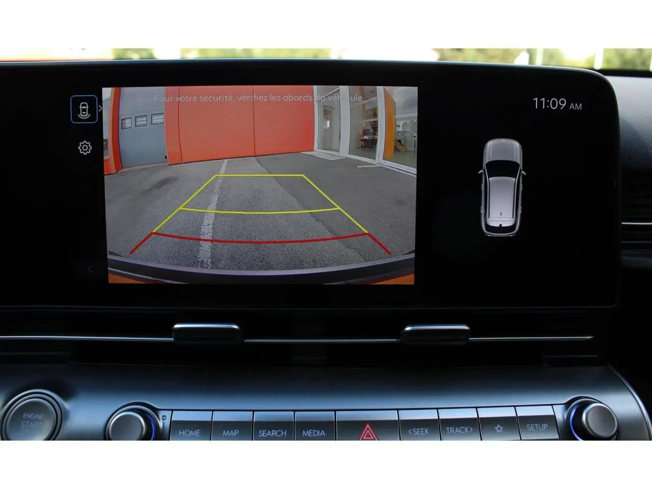 Écran tactile intérieur montrant la caméra de recul avec lignes de guidage actives sur Hyundai Kona 2024 rouge et toit noir.