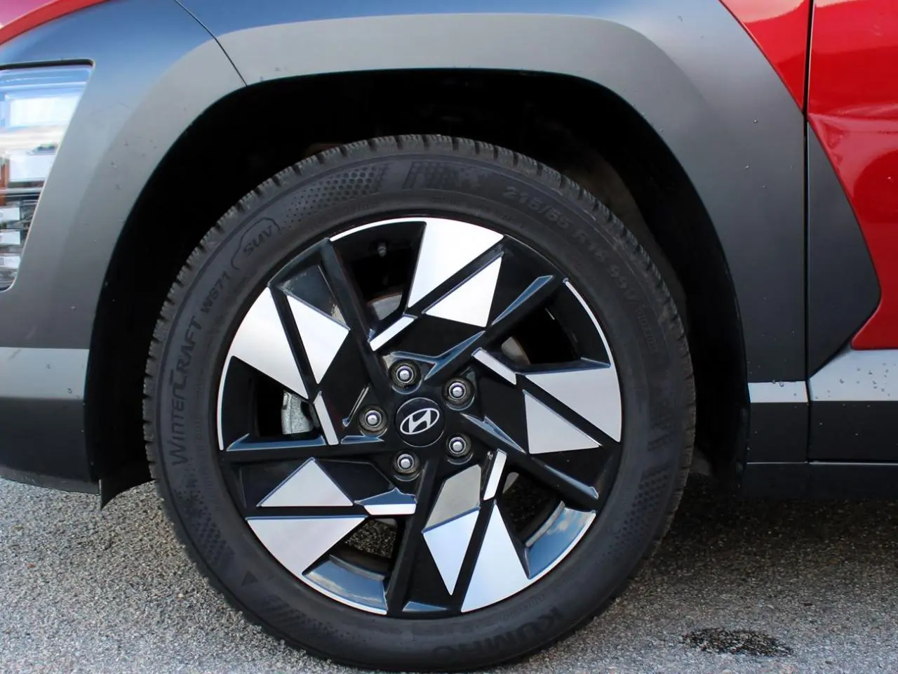 Gros plan sur la roue avant gauche du Hyundai Kona rouge Ultimate Metal avec jante alliage 17'' bicolore.