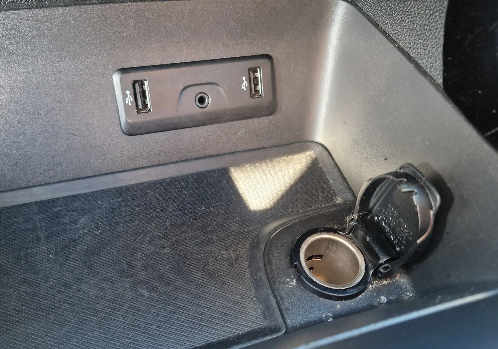 Détail de la console centrale du Renault Kadjar bleu cosmos 2020 montrant deux ports USB et une prise 12V ouverte.