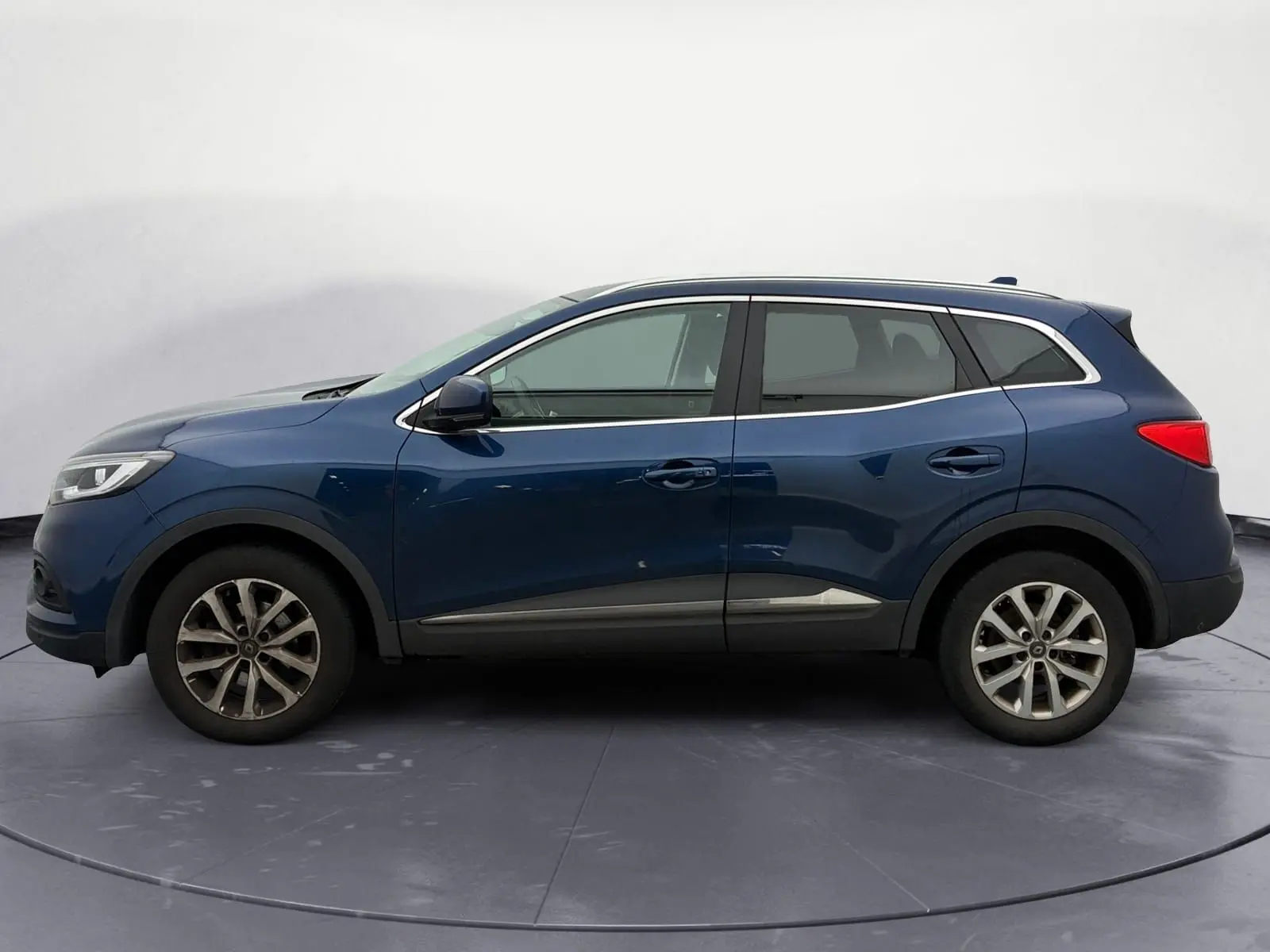 Vue de profil côté gauche d'un Renault Kadjar 1.5 Blue dCi 115 Business bleu cosmos avec jantes alliage 17 pouces.