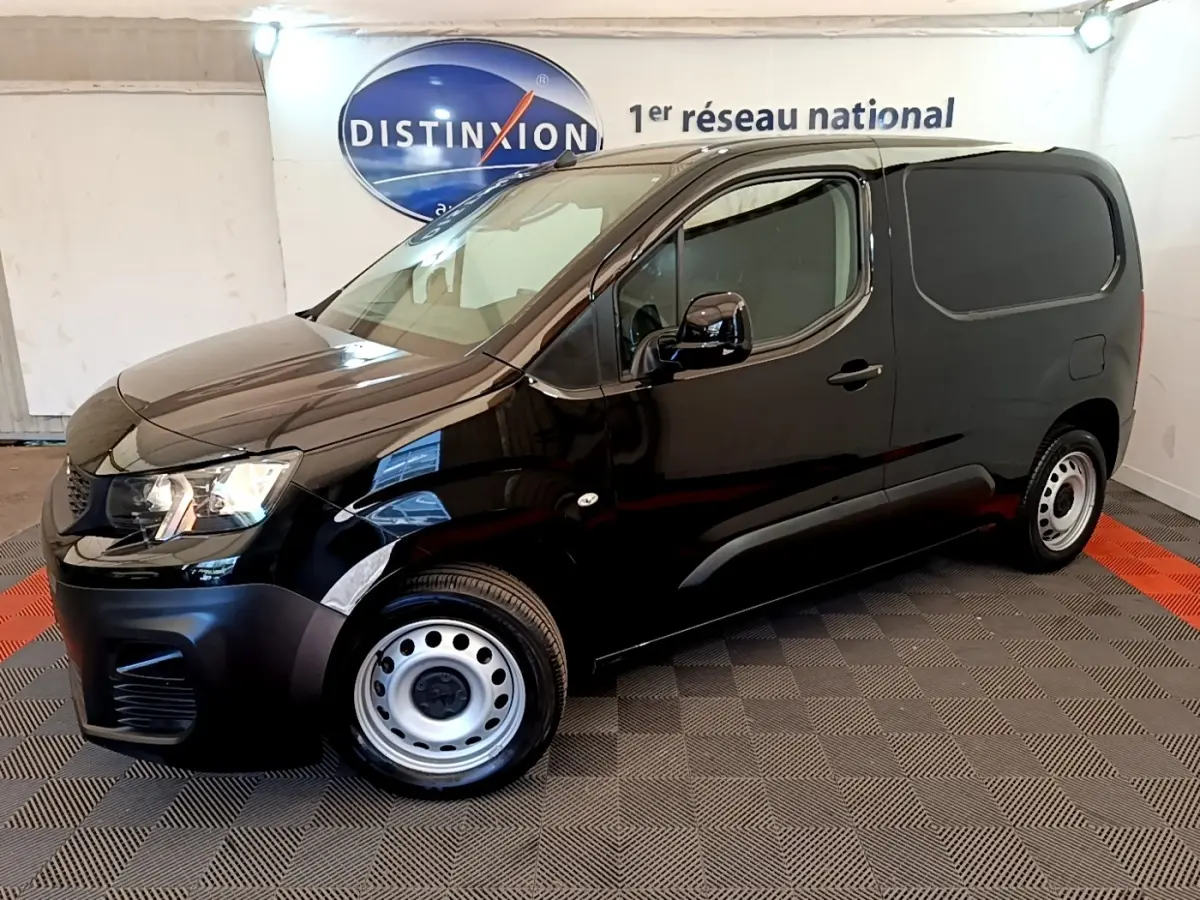 Vue de profil côté gauche d'un Peugeot Partner noir 2022 avec jantes acier et vitres arrière opaques dans un showroom.