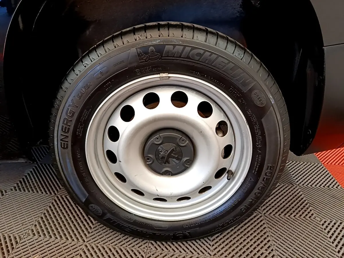 Gros plan sur la roue avant droite du Peugeot Partner noir, jante acier avec pneu Michelin Energy Saver.