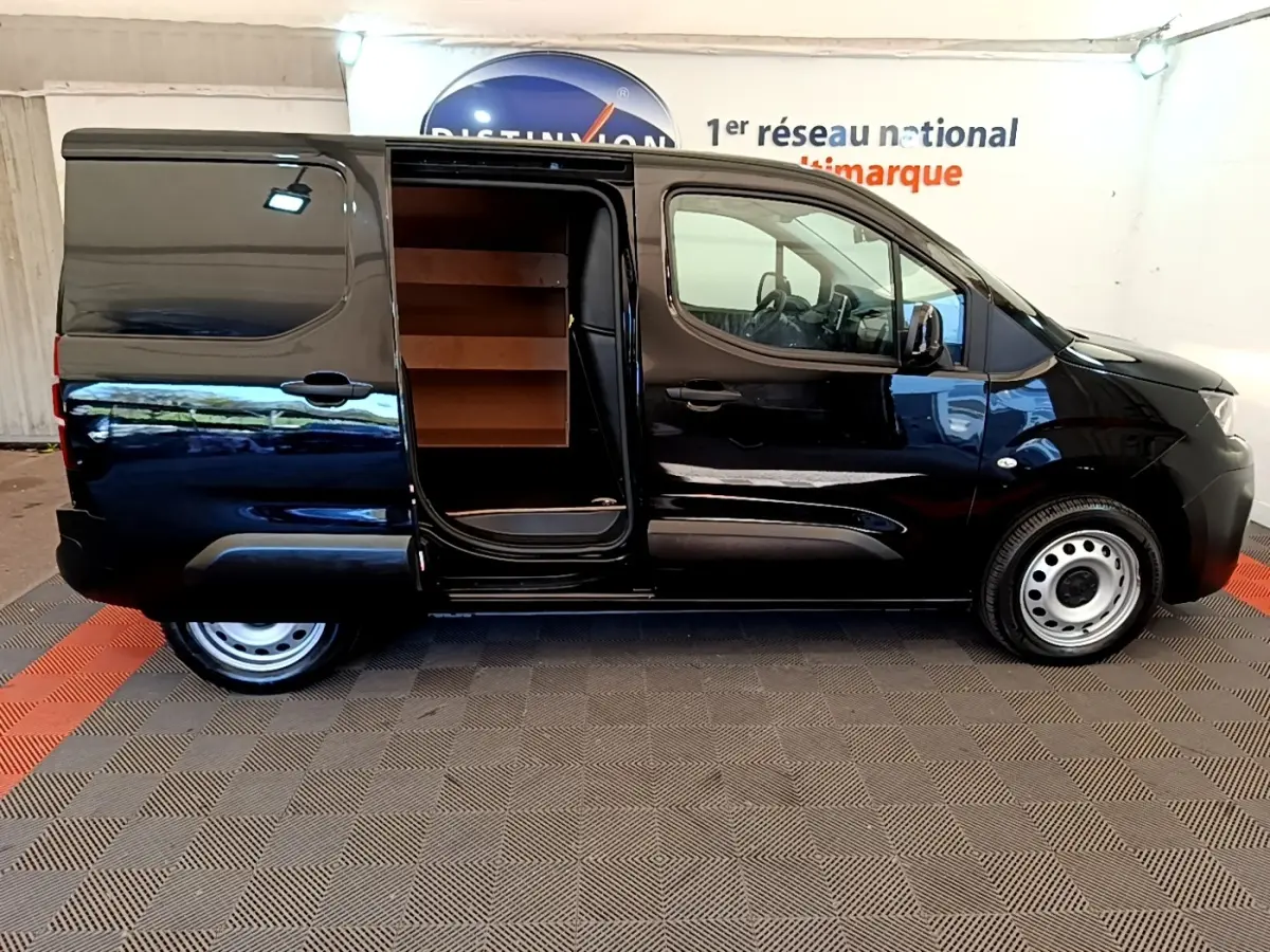Vue latérale droite d’un Peugeot Partner noir 2022 avec porte coulissante ouverte montrant l’intérieur de chargement.