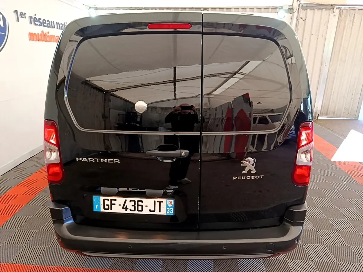 Vue arrière d’un Peugeot Partner noir 2022 avec portes battantes et plaque d’immatriculation française visible.