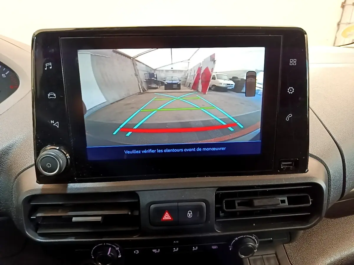 Écran tactile intérieur montrant la caméra de recul du Peugeot Partner noir, vue arrière avec lignes de guidage colorées.