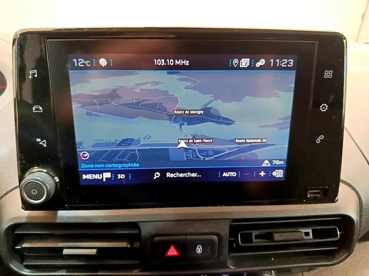 Écran tactile central avec navigation GPS affichée, tableau de bord noir du Peugeot Partner 2022, vue de face rapprochée.