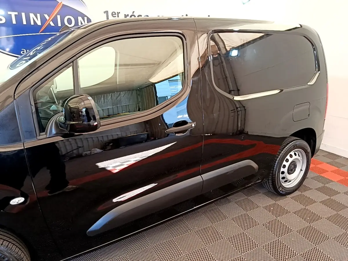 Profil côté gauche du Peugeot Partner noir 2022 avec porte latérale coulissante et jantes acier simples.