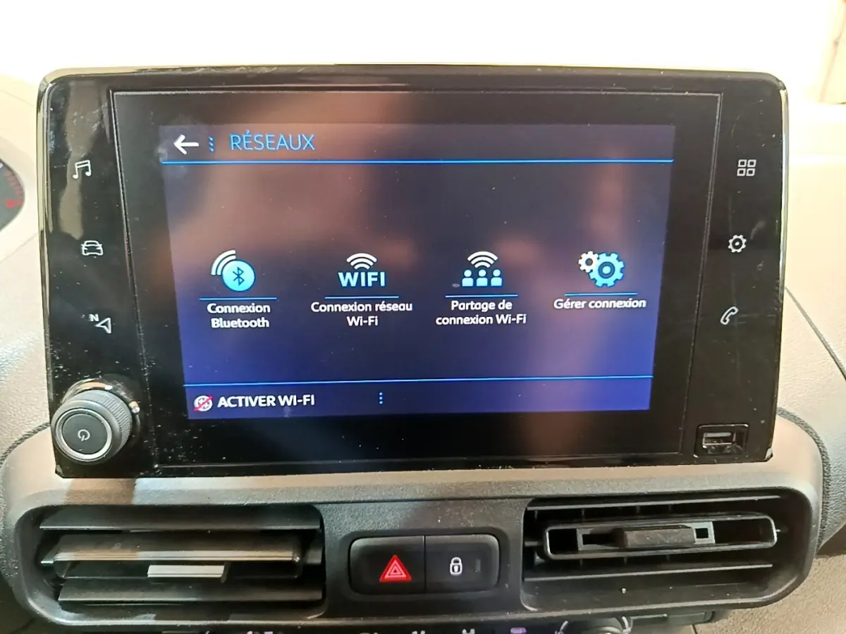 Écran tactile central affichant les options réseau Wi-Fi et Bluetooth dans l'habitacle du Peugeot Partner noir.