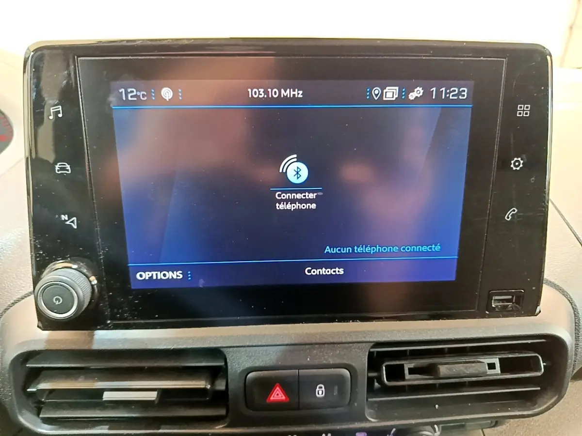 Vue rapprochée de l’écran tactile central du Peugeot Partner noir, affichant la connexion Bluetooth au téléphone.
