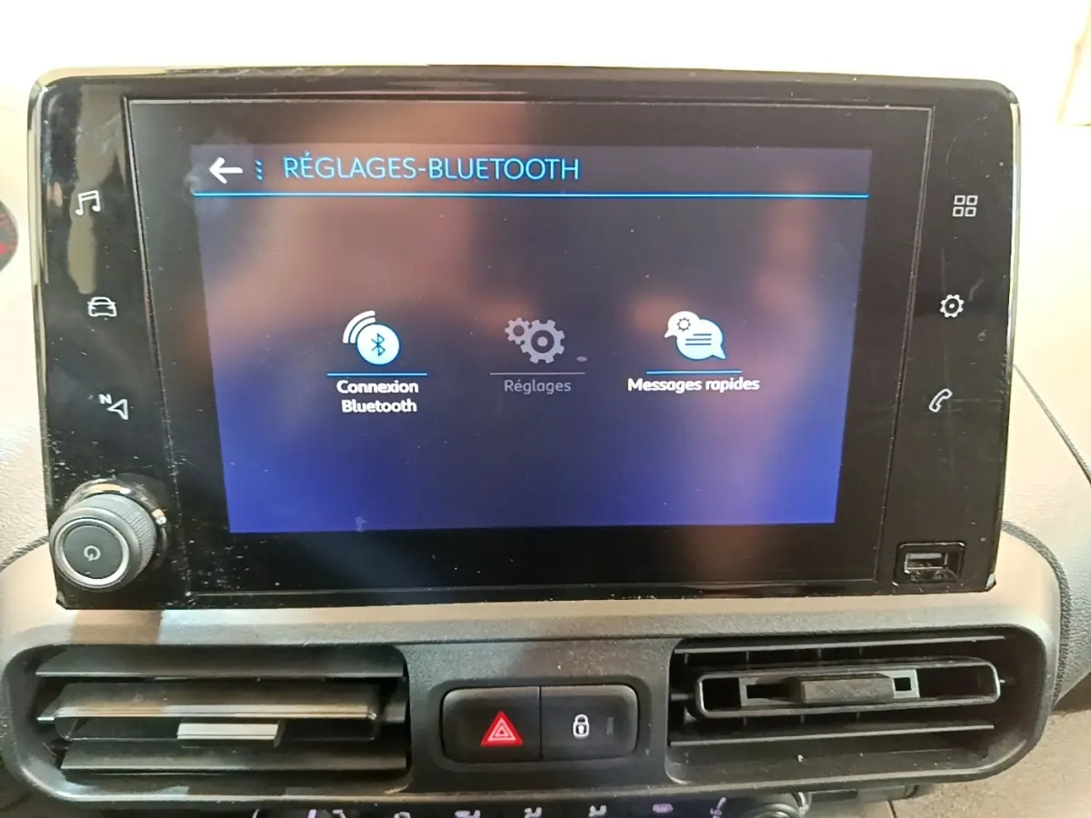 Écran tactile central du Peugeot Partner noir 2022 affichant les réglages Bluetooth avec commandes autour.
