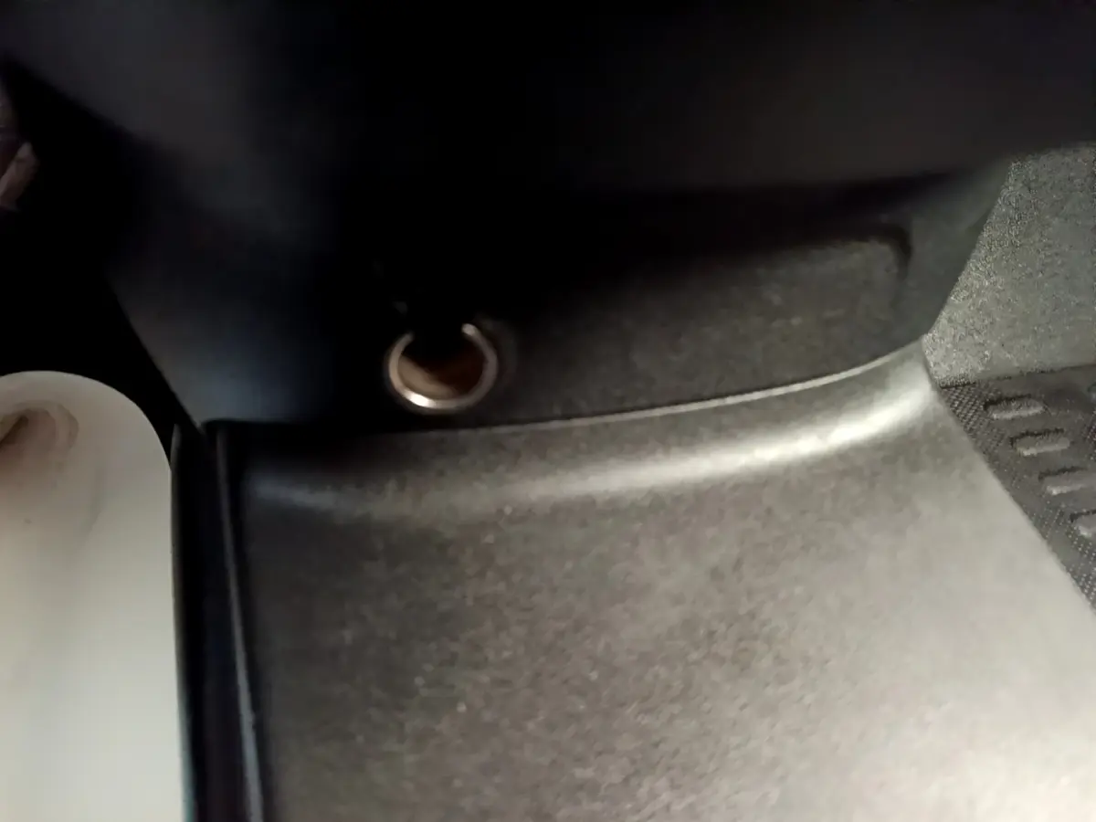 Prise 12V avant en gros plan dans l'habitacle du Peugeot Partner noir, vue rapprochée du tableau de bord.