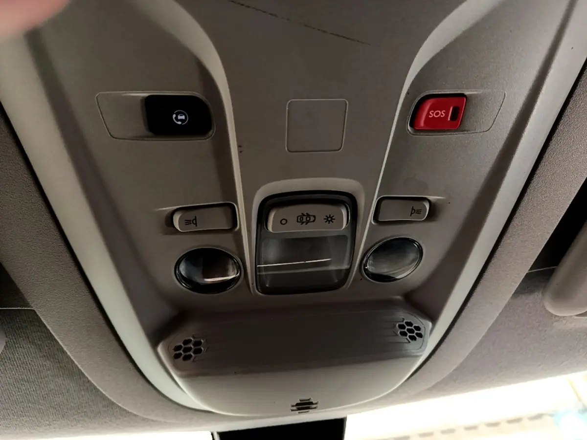 Vue en gros plan du plafonnier intérieur du Peugeot Partner noir, avec boutons d’éclairage et alerte SOS rouge.